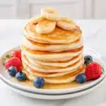 Easy Banana Pancakes: The Fluffiest 20-Minute Breakfast 2 Easy banana pancakes topped with fresh banana slices and maple syrup